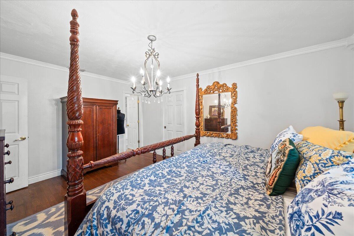 1244 Cimarron Circle Northeast Palm Bay, FL 32905 - Photo 17 of 38 a bedroom with a bed and a chandelier