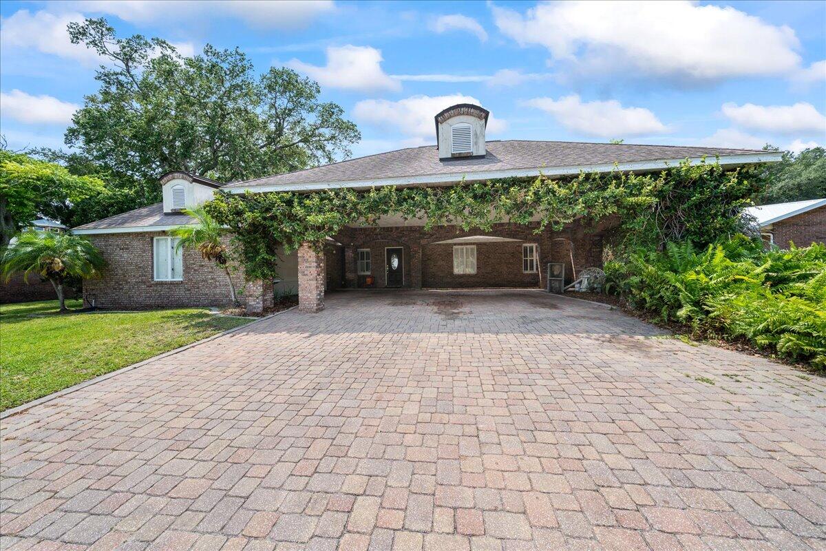 1244 Cimarron Circle Northeast Palm Bay, FL 32905 - Photo 2 of 38 a front view of a house with a yard and a garden