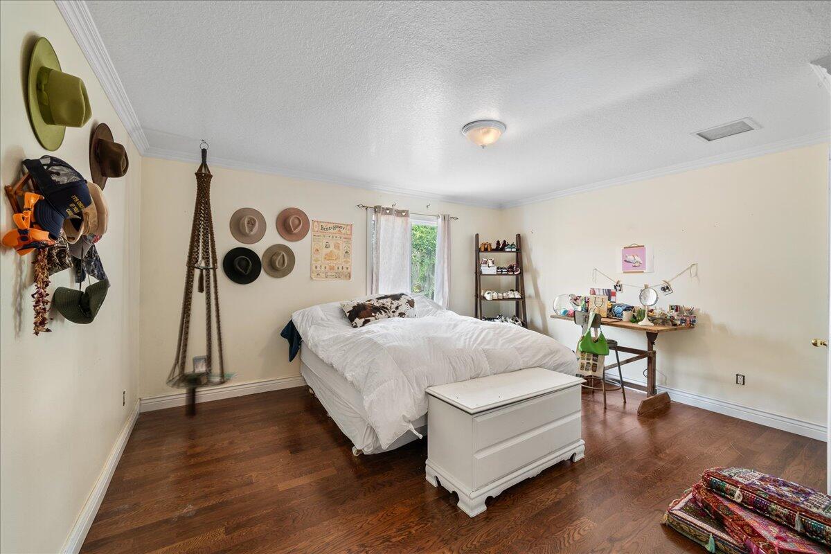 1244 Cimarron Circle Northeast Palm Bay, FL 32905 - Photo 23 of 38 a spacious bedroom with a bed and a chandelier