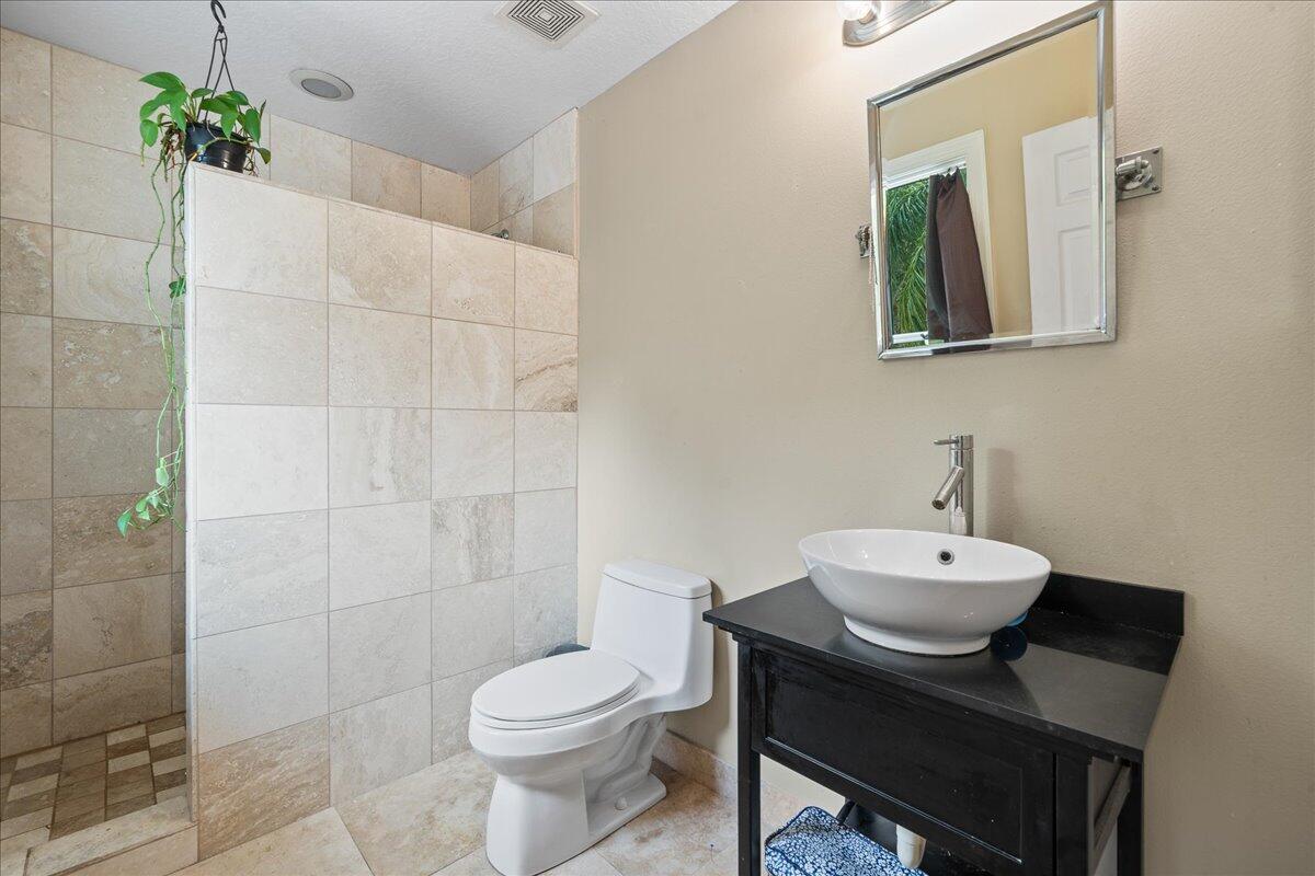 1244 Cimarron Circle Northeast Palm Bay, FL 32905 - Photo 25 of 38 a bathroom with a toilet a sink and mirror