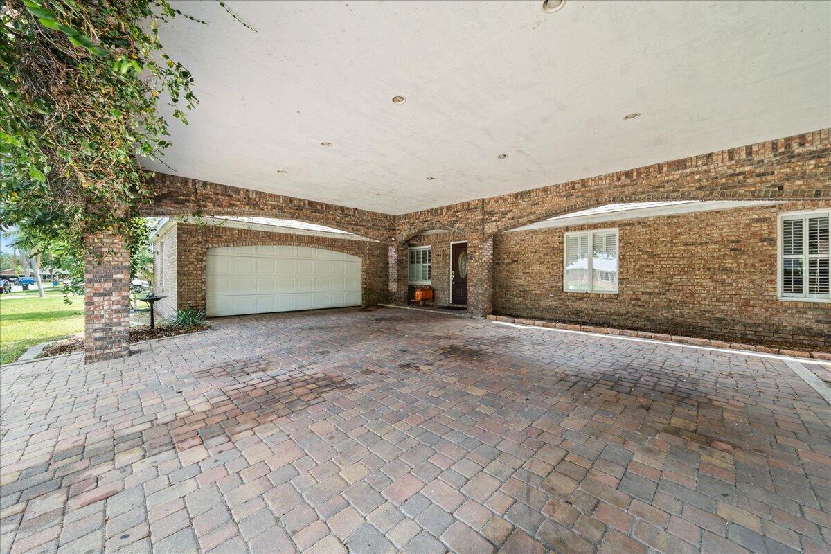 1244 Cimarron Circle Northeast Palm Bay, FL 32905 - Photo 37 of 38 a view of a house with a yard and garage