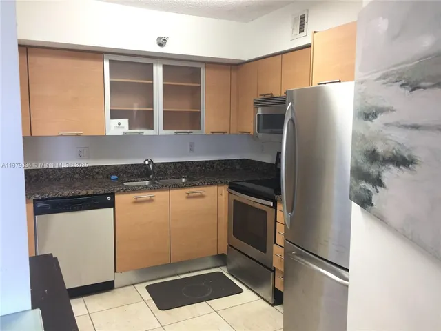 a kitchen with stainless steel appliances granite countertop a refrigerator and a stove