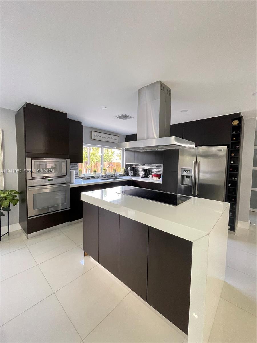 6901 Northwest 82nd Court Tamarac, FL 33321 - Photo 4 of 13 a kitchen with stainless steel appliances a stove a microwave and a refrigerator