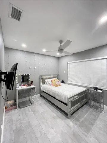 a spacious bedroom with a bed and a chair