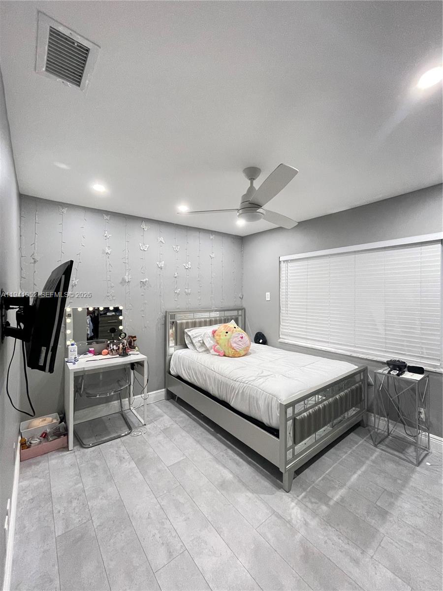 6901 Northwest 82nd Court Tamarac, FL 33321 - Photo 9 of 13 a spacious bedroom with a bed and a chair