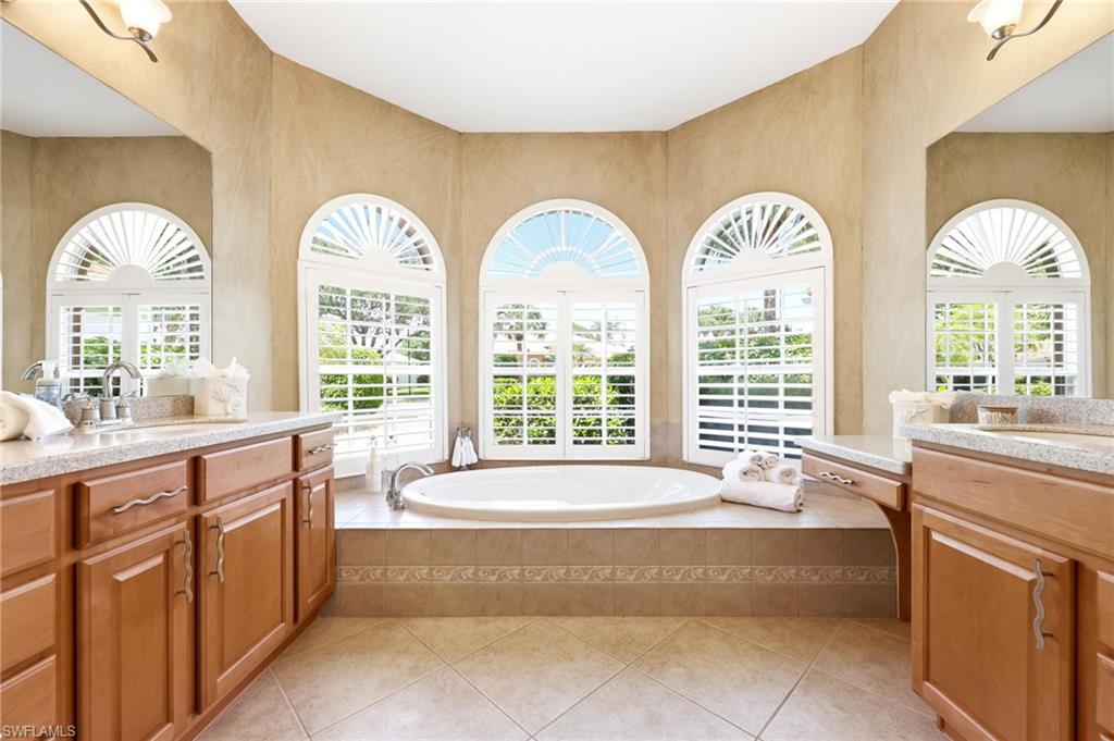 3951 Ruxton Road Naples, FL 34116 - Photo 17 of 35 a spacious bathroom with a large tub and large windows