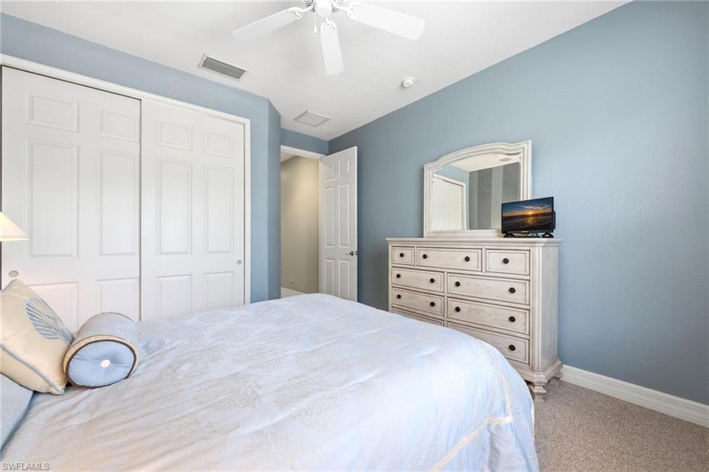 3951 Ruxton Road Naples, FL 34116 - Photo 28 of 35 a bedroom with a bed and a mirror