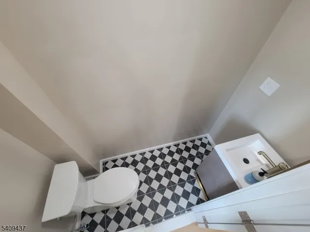 a view of an empty room with wooden floor and stairs