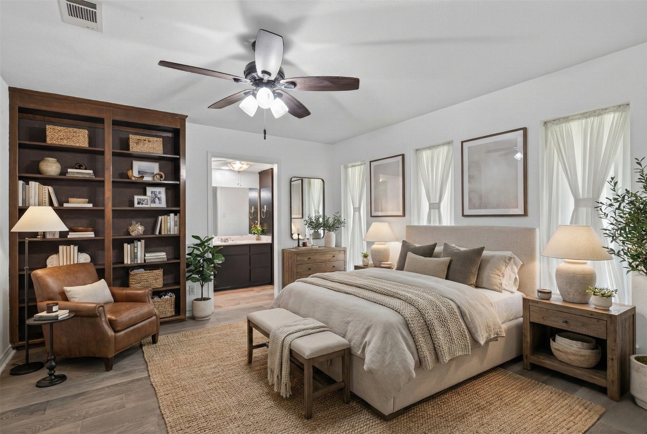 15335 Robin Trail Conroe, TX 77302 - Photo 17 of 38 Spacious primary suite featuring a tranquil retreat with ceiling fan and built-in shelving for ample storage. The generous room includes an en-suite bathroom. Large windows allow natural light to fill the space, creating a peaceful and restful atmosphere.