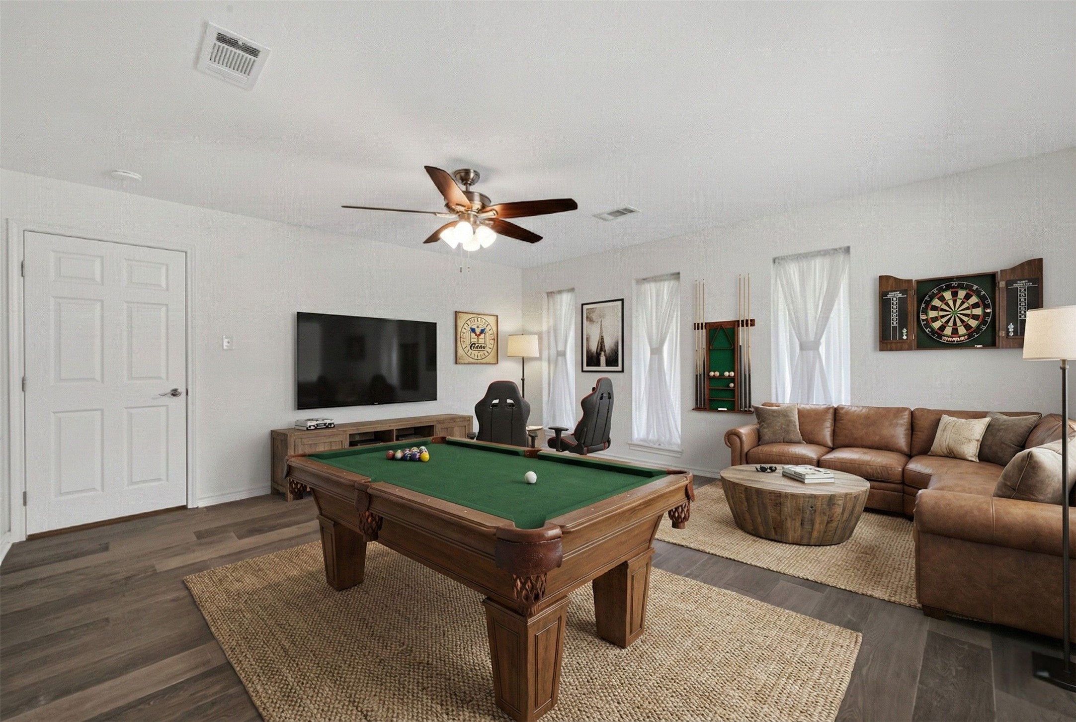 15335 Robin Trail Conroe, TX 77302 - Photo 32 of 38 Versatile flex space with ceiling fan and beautiful wood-look flooring, virtually staged as a game room to demonstrate its recreational potential. The generous layout offers ample space for entertainment and includes a convenient en-suite half bath. This multi-functional room can easily adapt as a fourth bedroom, home office, media room, or game room to meet your changing needs.