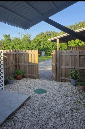 a view of a backyard with plants and wooden fence
