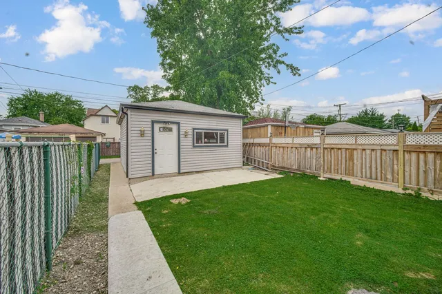 a view of a backyard with table and chairs and wooden fence