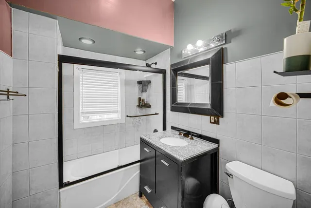 a bathroom with a sink toilet double vanity and mirror