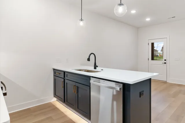 a kitchen with a sink and wooden floor