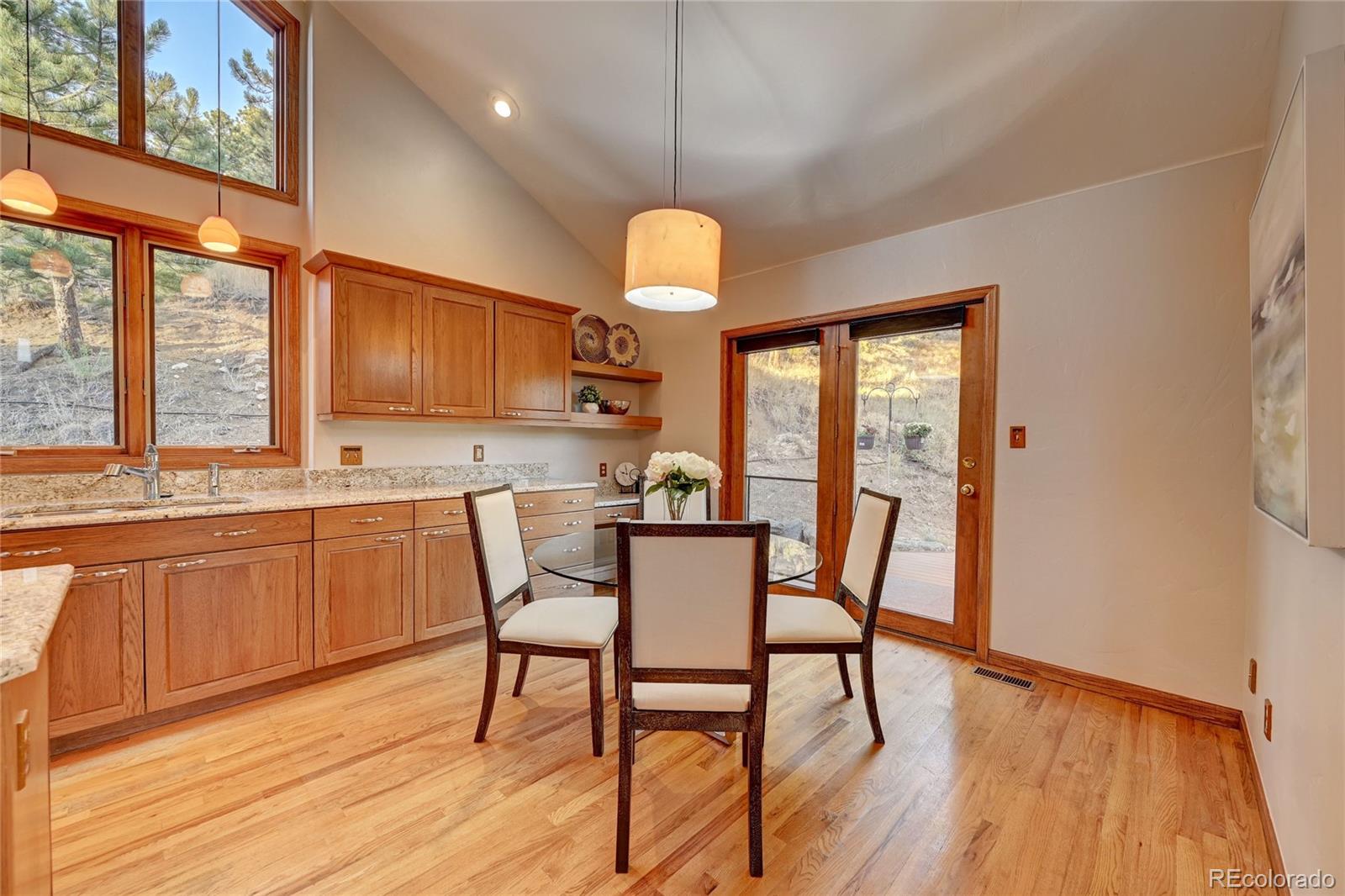 734 Spring Ranch Drive Golden, CO 80401 - Photo 14 of 40 a view of a dining room with furniture a chandelier and wooden floor