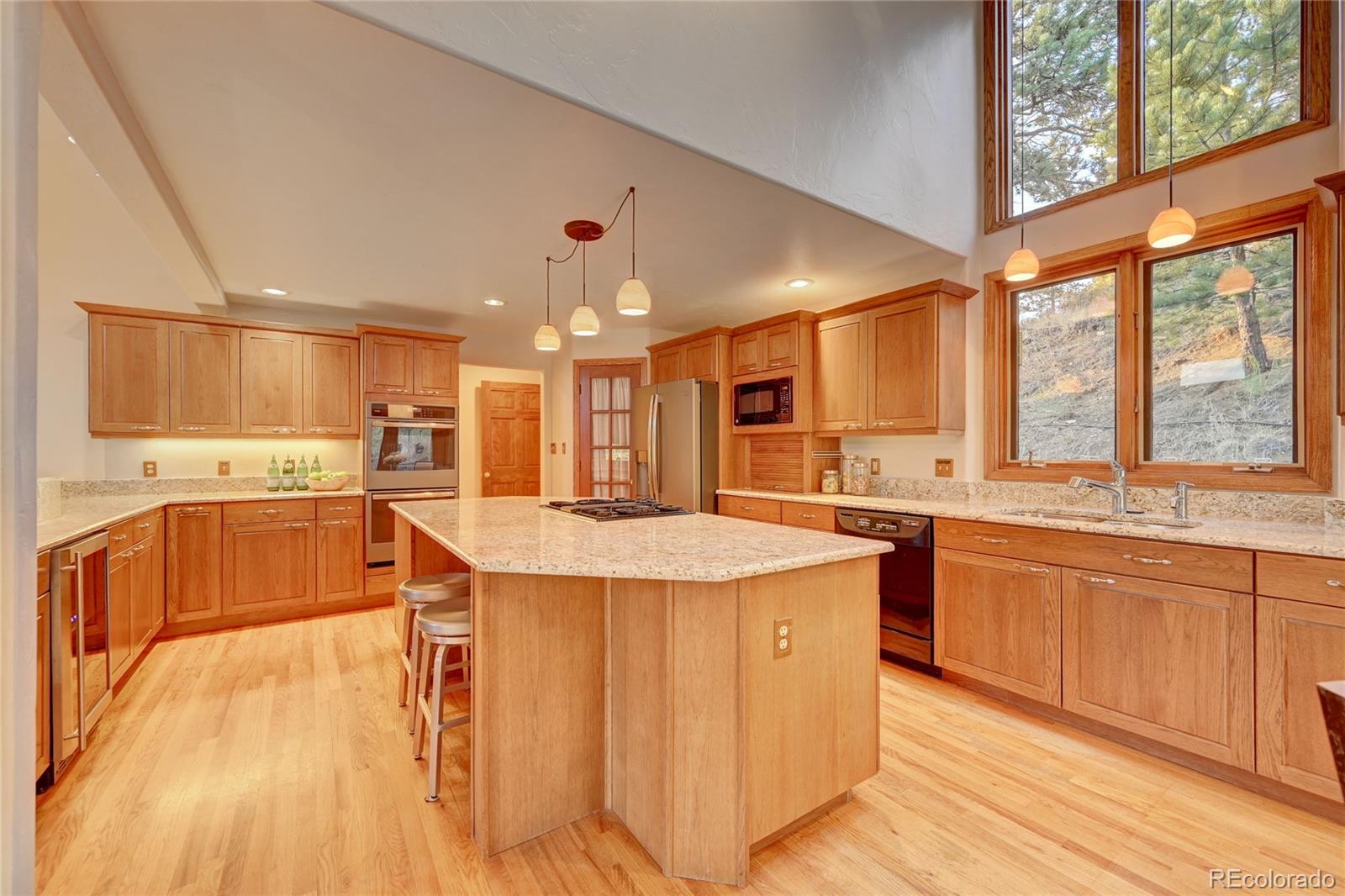 734 Spring Ranch Drive Golden, CO 80401 - Photo 15 of 40 a kitchen with stainless steel appliances kitchen island granite countertop a sink and cabinets