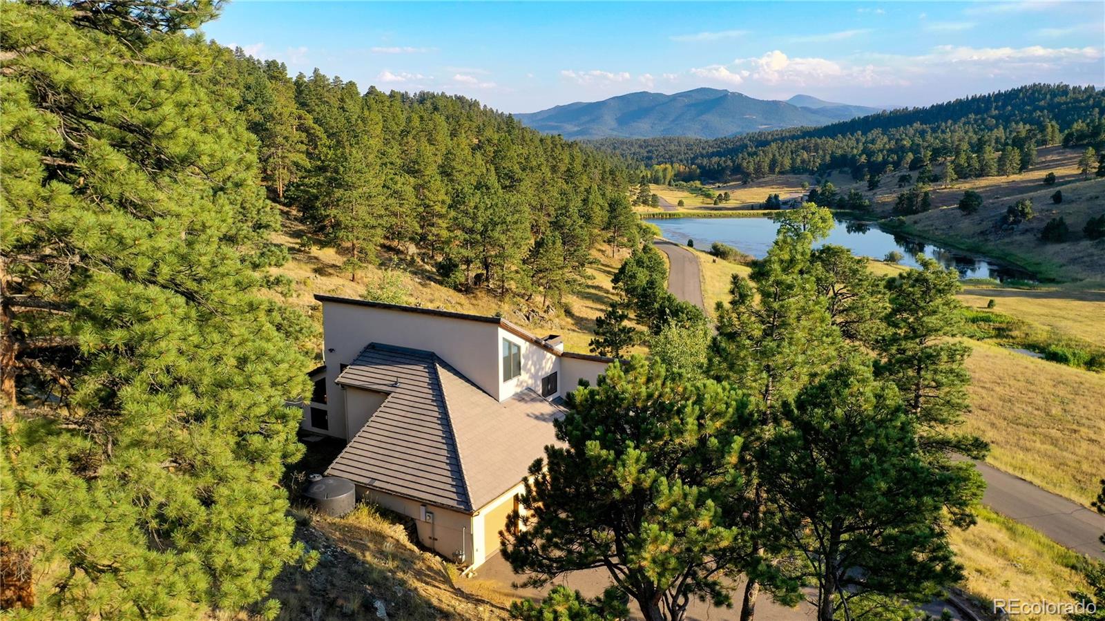 734 Spring Ranch Drive Golden, CO 80401 - Photo 32 of 40 a view of a lush green forest with mountains in the background