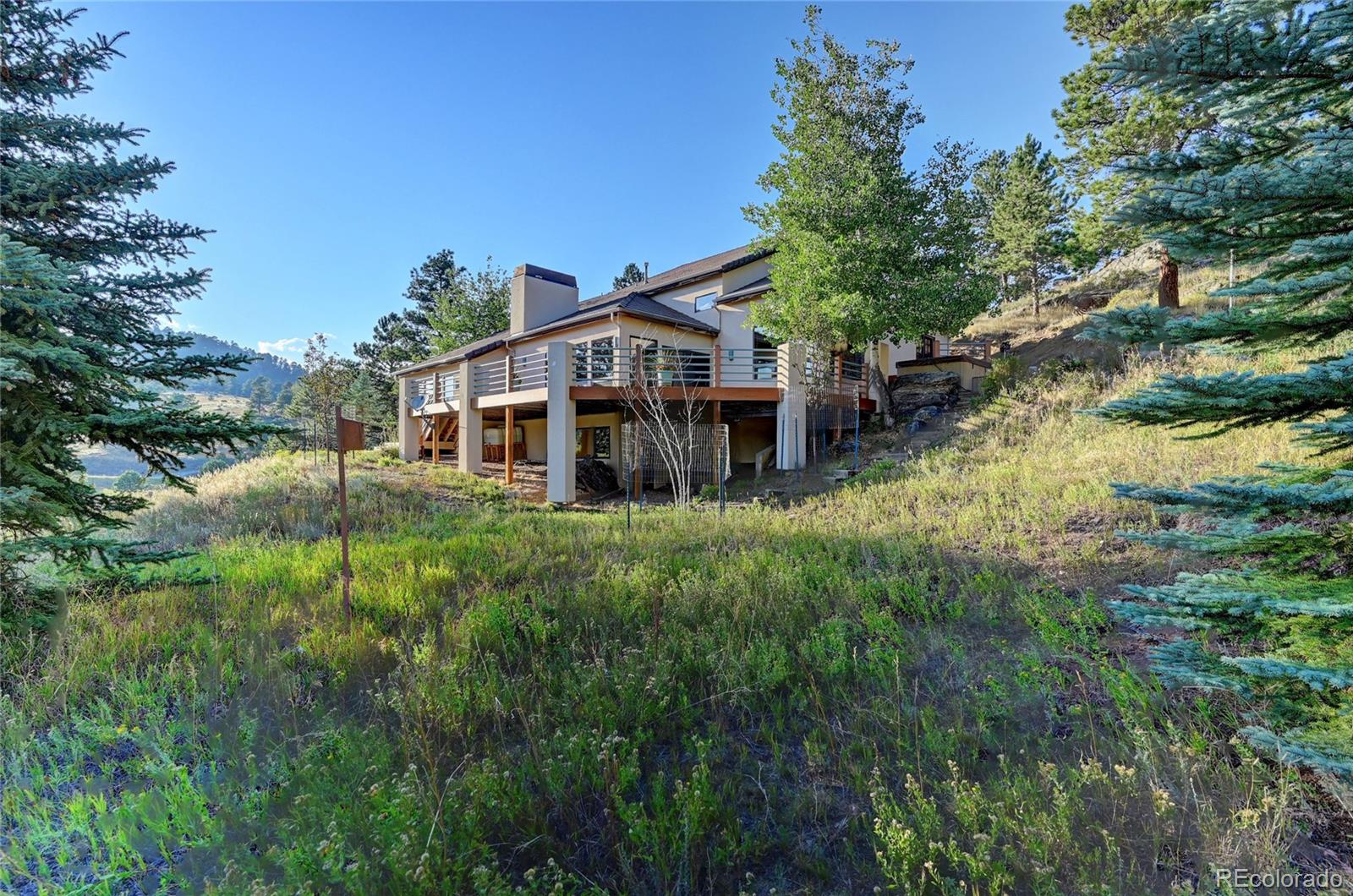 734 Spring Ranch Drive Golden, CO 80401 - Photo 5 of 40 a view of a house with a big yard and large trees