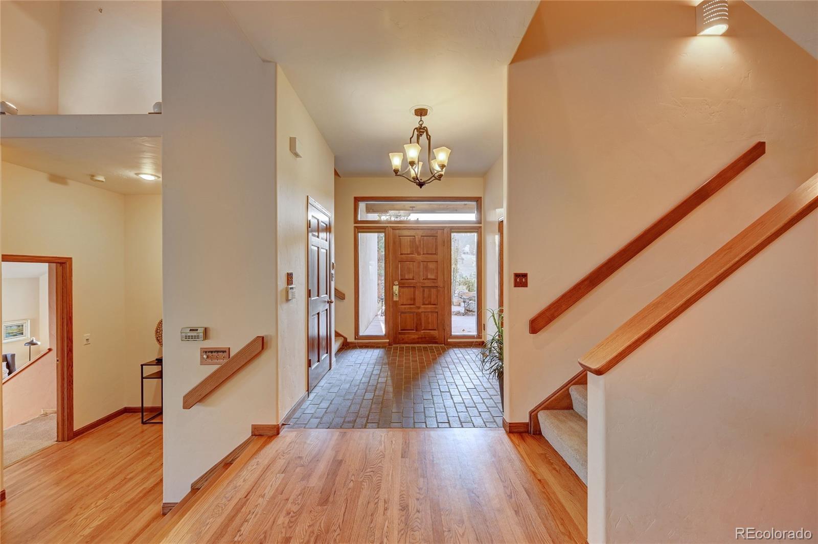 734 Spring Ranch Drive Golden, CO 80401 - Photo 7 of 40 a hallway with wooden floor chandelier and entryway
