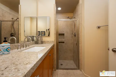 a bathroom with a granite countertop sink mirror and shower