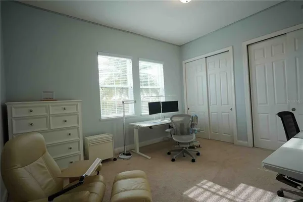 a view of a workspace with furniture and a window