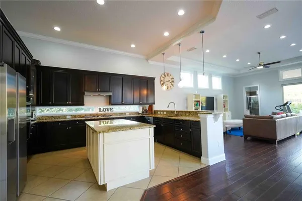 a large kitchen with stainless steel appliances and a view of living room