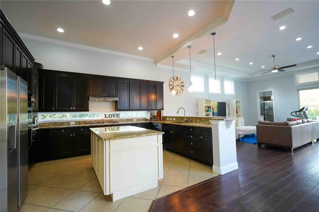6219 Tiroco Way Windermere, FL 34786 - Photo 10 of 41 a large kitchen with stainless steel appliances and a view of living room