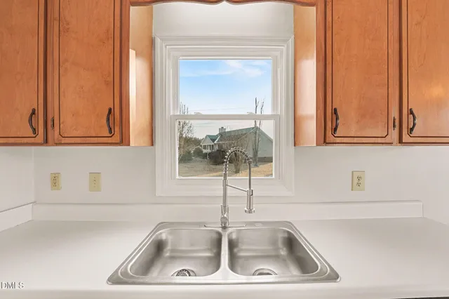 a kitchen with stainless steel appliances a refrigerator a sink and white cabinets