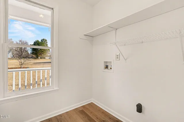 an empty room with windows and ceiling fan