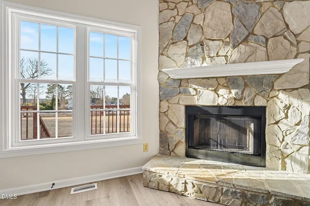 a living room with a fireplace and a window