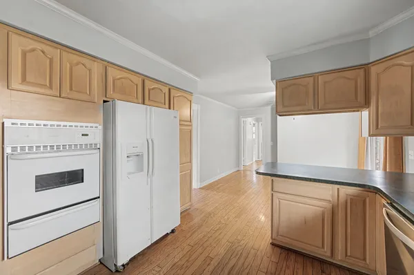 a view of kitchen with wooden floor and electronic appliances