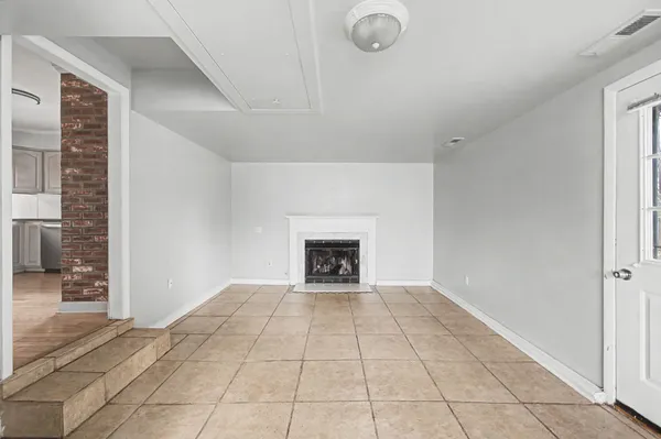 a view of an empty room with a fireplace and a window
