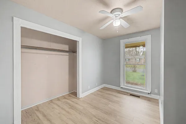 an empty room with fan and windows