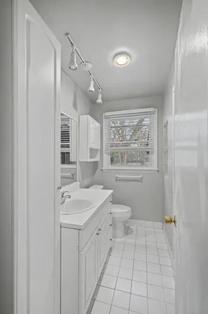 a bathroom with a granite countertop sink a toilet a large mirror and shower