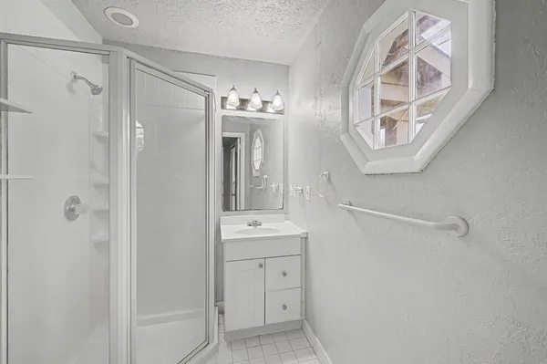 a bathroom with a sink a mirror a vanity and a shower