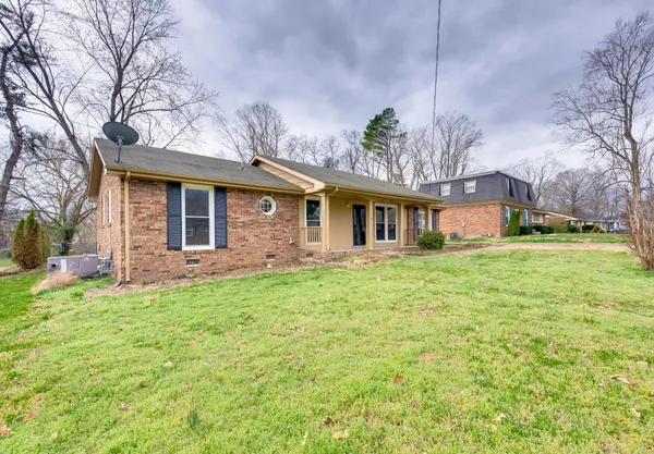 a front view of a house with a garden and trees
