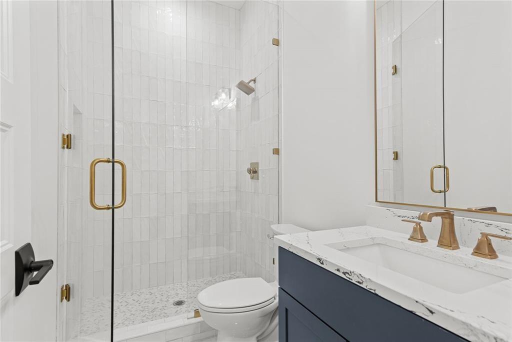 240 Highlands Ball Ground, GA 30107 - Photo 16 of 57 a bathroom with a granite countertop sink a toilet and shower