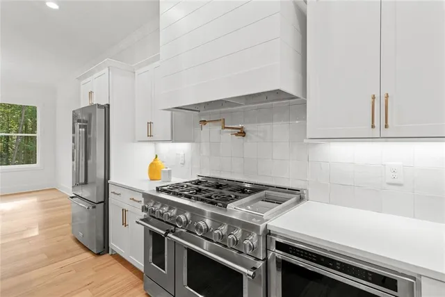 a kitchen with white cabinets and white appliances