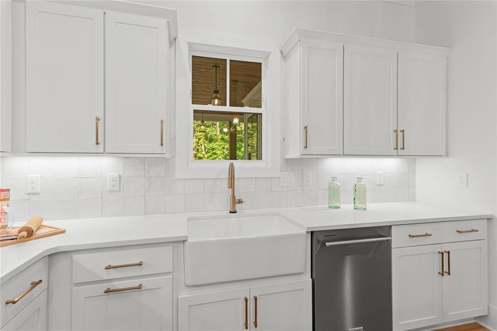 240 Highlands Ball Ground, GA 30107 - Photo 19 of 57 a kitchen with white cabinets and white appliances