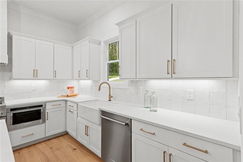 240 Highlands Ball Ground, GA 30107 - Photo 20 of 57 a kitchen with white cabinets and white appliances