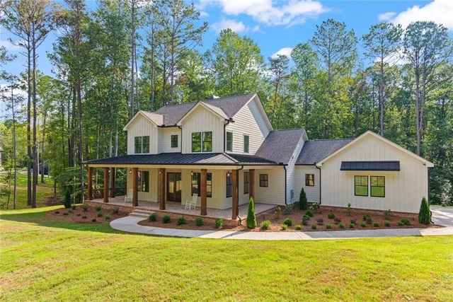 a view of a large pool with lawn chairs under an umbrella