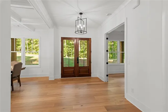 a dining room with furniture a chandelier and wooden floor