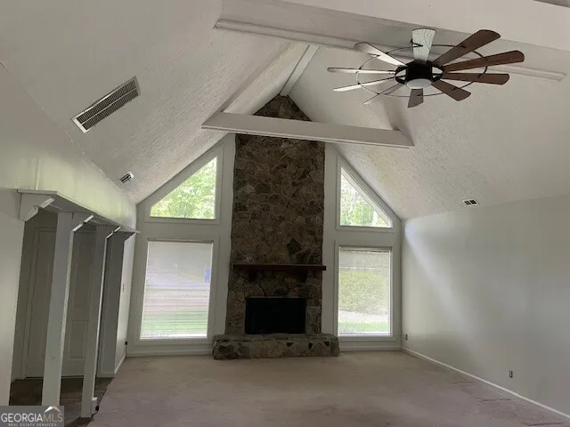 an empty room with windows cabinet and fireplace