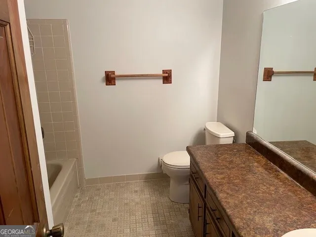 a bathroom with a granite countertop sink and toilet