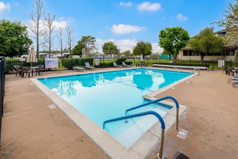 a view of a swimming pool with outdoor seating and a garden
