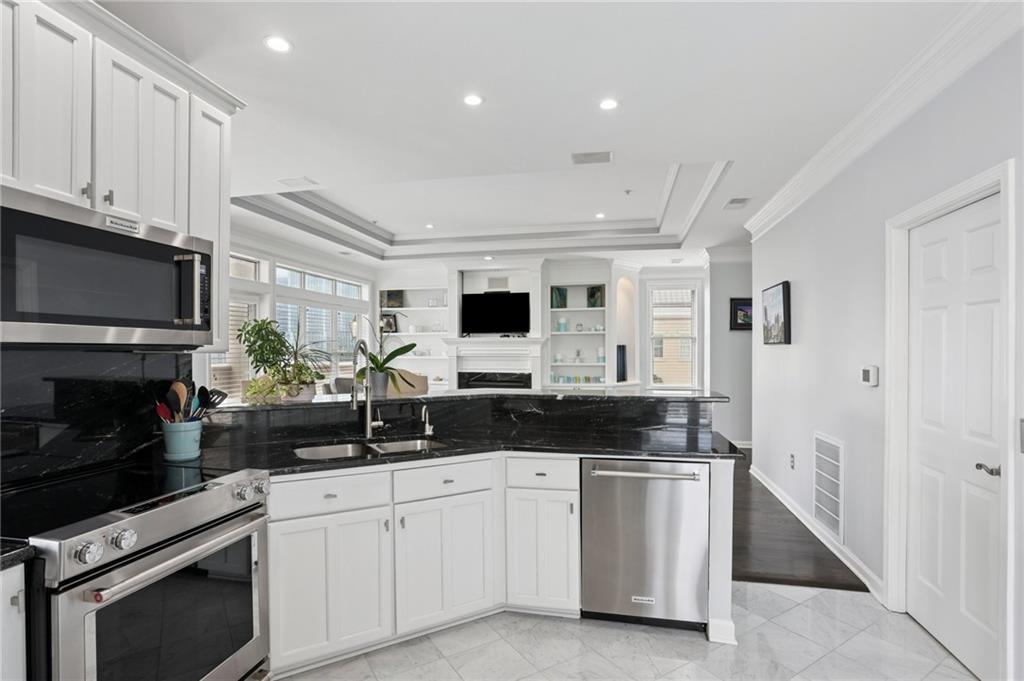 3334 Peachtree Road Northeast, Unit 1908 Atlanta, GA 30326 - Photo 12 of 46 a kitchen with stainless steel appliances granite countertop a stove a sink and a microwave
