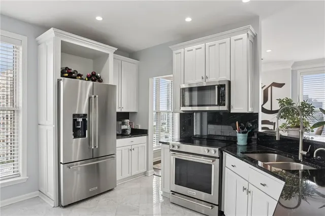 a kitchen with stainless steel appliances granite countertop a refrigerator and a stove top oven