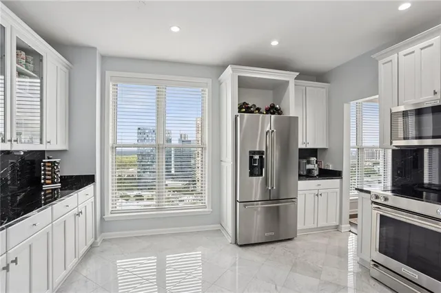 a kitchen with stainless steel appliances a refrigerator sink and microwave