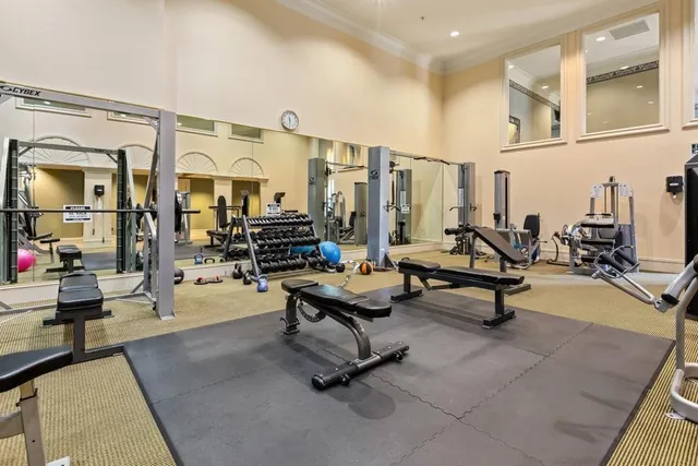 a living room with stainless steel appliances dining table furniture and a flat screen tv