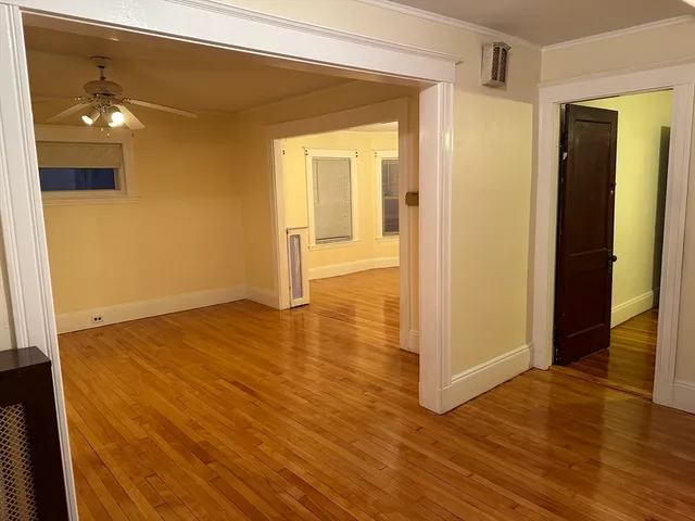 a view of a room with wooden floor and a bathroom